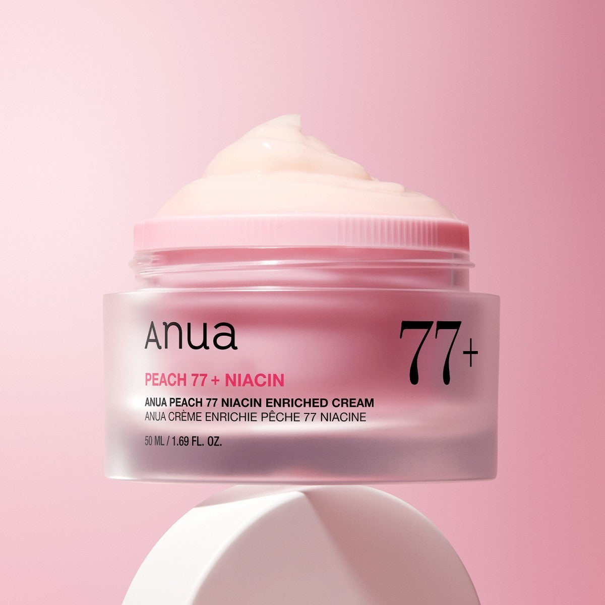 bareskin.lt Anua Peach 77 Niacin Enriched Cream in a pink jar with a light gel texture against a soft pink background