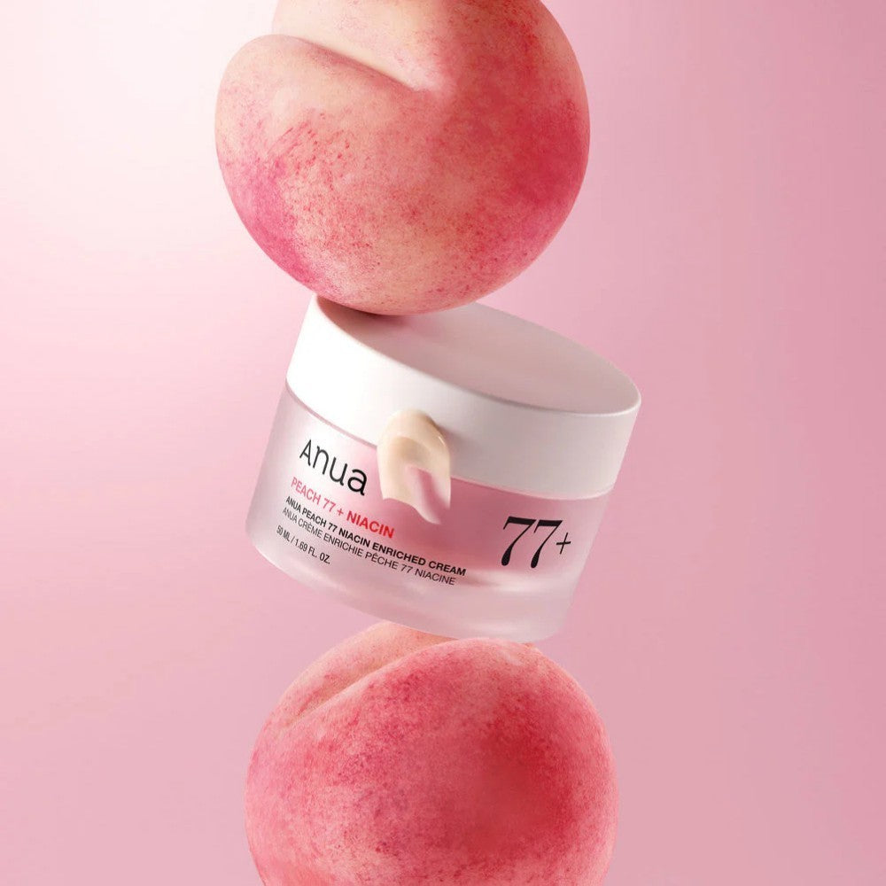 bareskin.lt Anua Peach 77 Niacin Enriched Cream in a jar balanced between two fresh peaches on a pink background