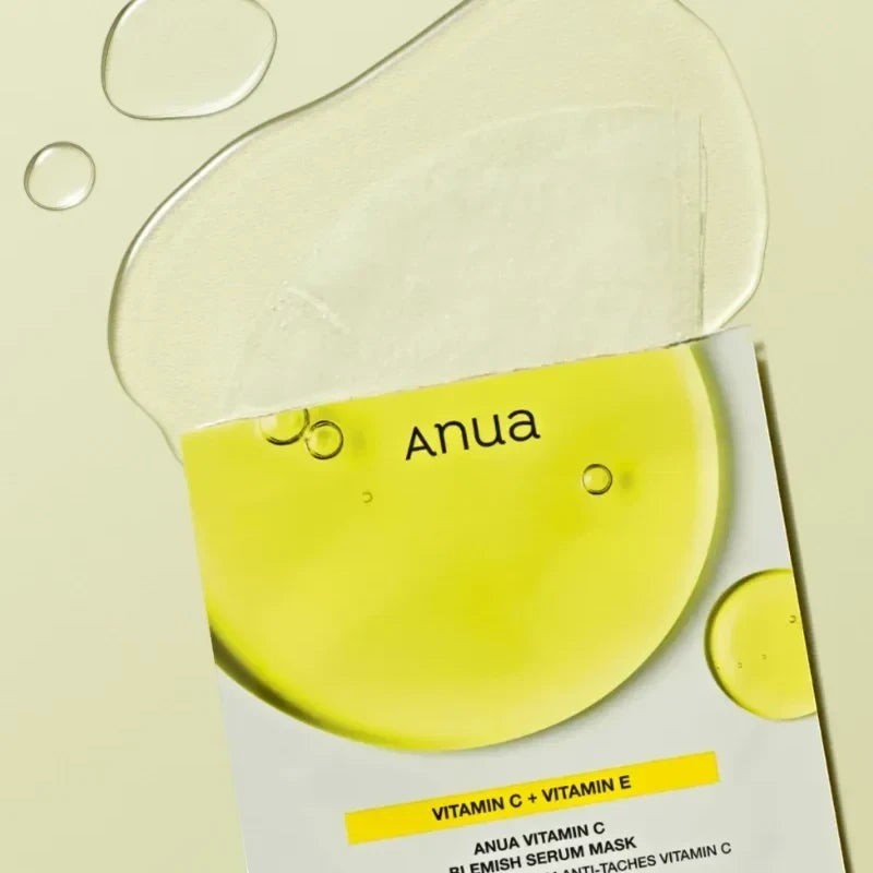 Anua Vitamin C Blemish Serum sheet mask from bareskin.lt with a bright yellow serum splash on a light green background