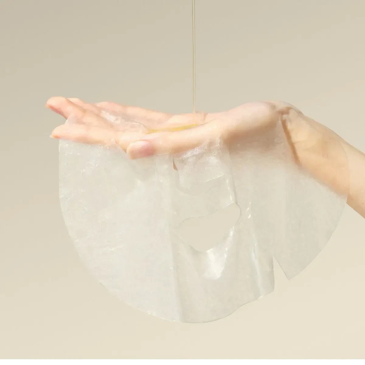 bareskin.lt Anua Vitamin C Blemish Serum Mask sheet mask being held in a hand with serum dripping onto it