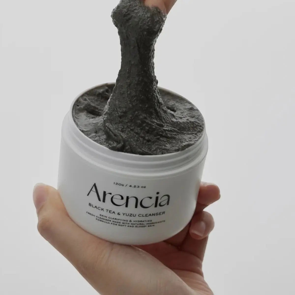 bareskin.lt Arencia Black Tea Rice Mochi Cleanser with a thick, dark, stretchy texture being scooped from a jar.