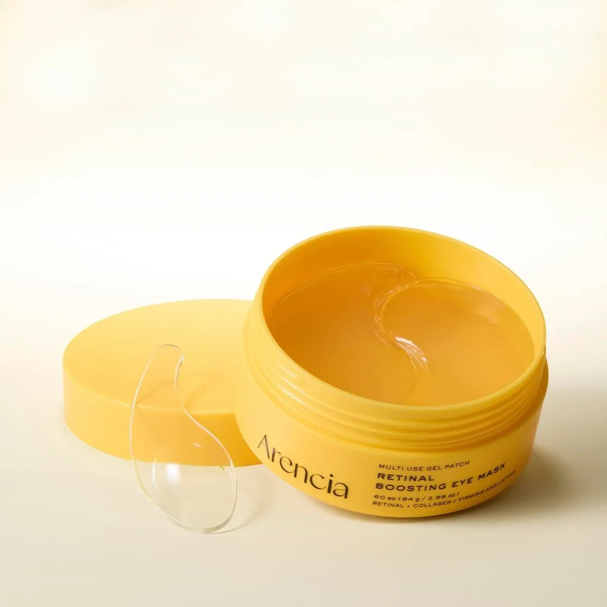 bareskin.lt Arencia Retinal Boosting Eye Mask in a yellow jar with a clear spatula on a light background
