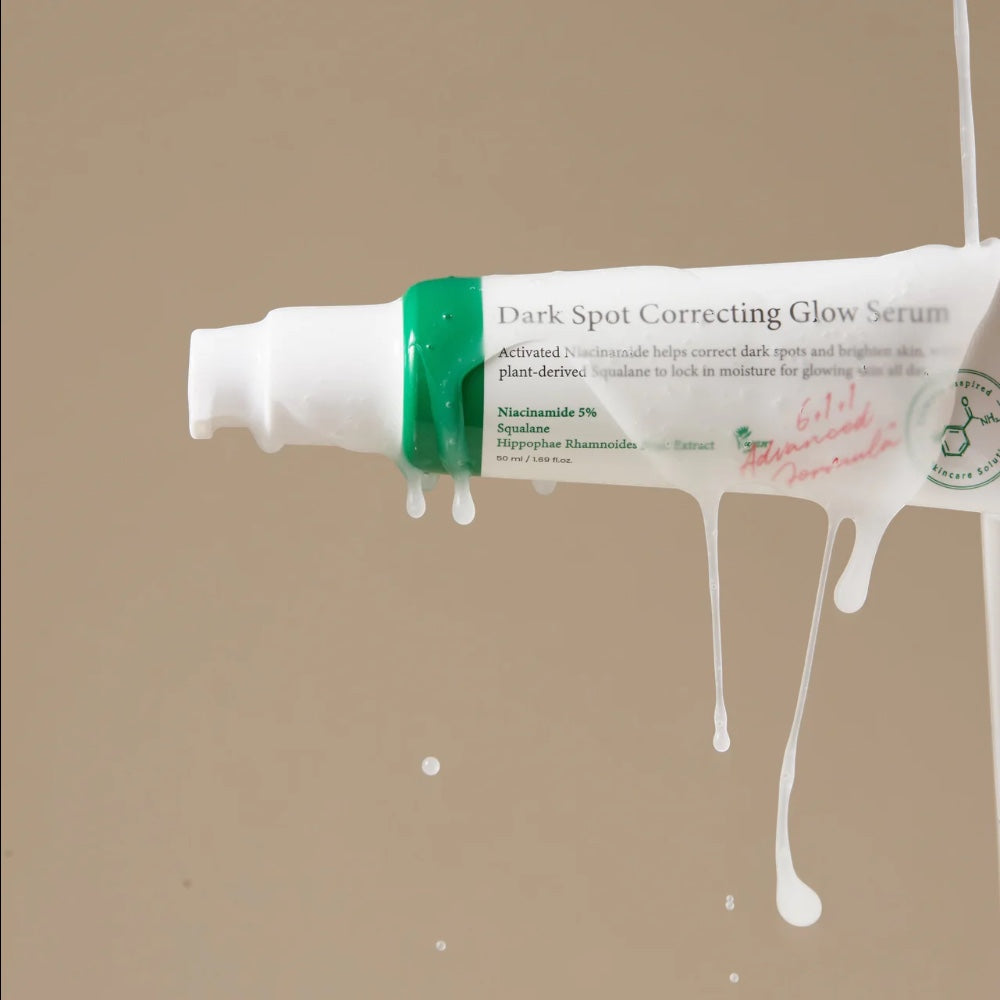 bareskin.lt Axis-Y Dark Spot Correcting Glow Serum tube with white serum dripping against a neutral beige background.