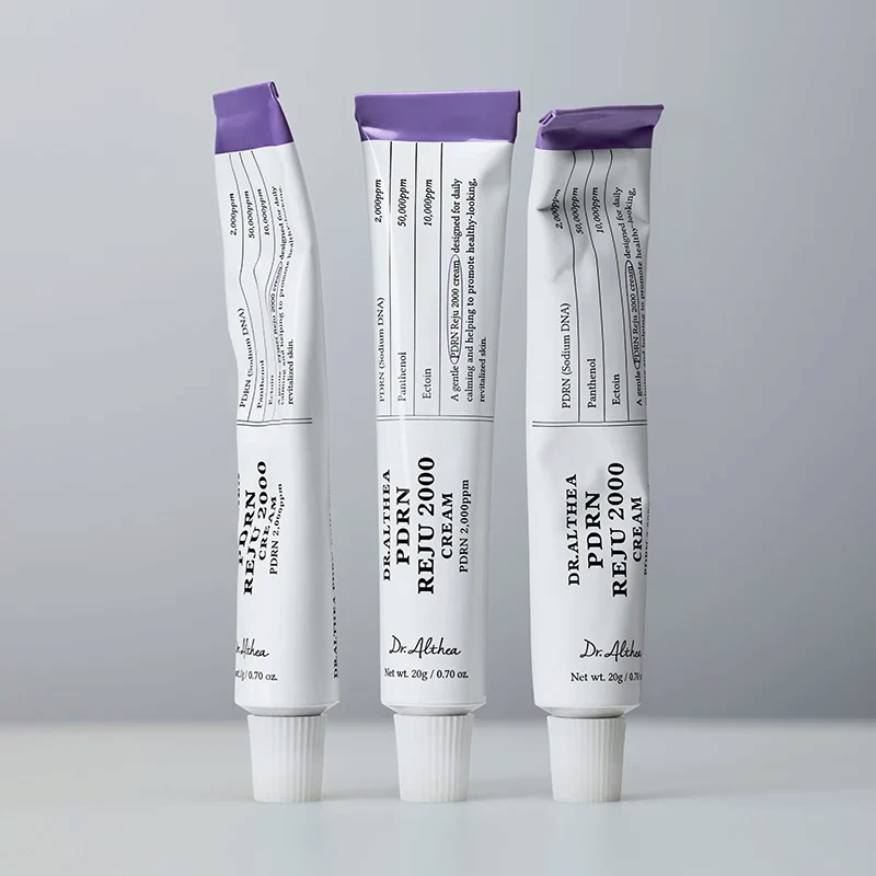 Three tubes of bareskin.lt Dr.Althea PDRN Reju 2000 Cream with white packaging and purple caps on a grey background.
