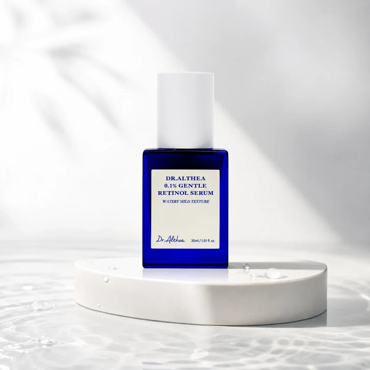 bareskin.lt Dr.Althea 0.1 Gentle Retinol Serum in a blue glass bottle on a white stone platform with water ripples