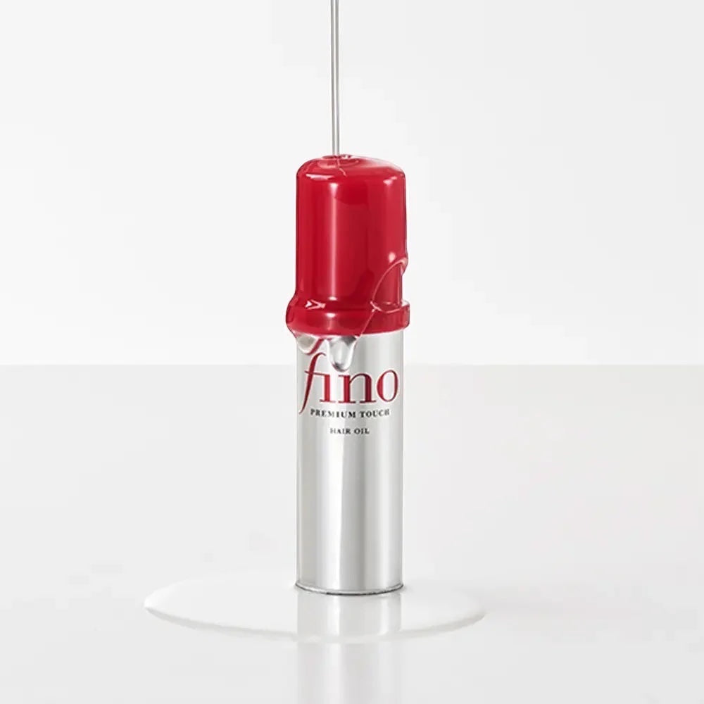 bareskin.lt Fino Premium Touch hair oil bottle with clear oil dripping down the red cap against a white background