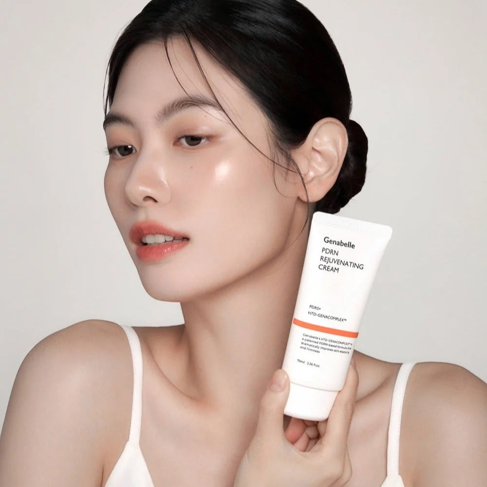 Woman with glowing skin holding a white Genabelle PDRN Rejuvenating Cream tube from bareskin.lt