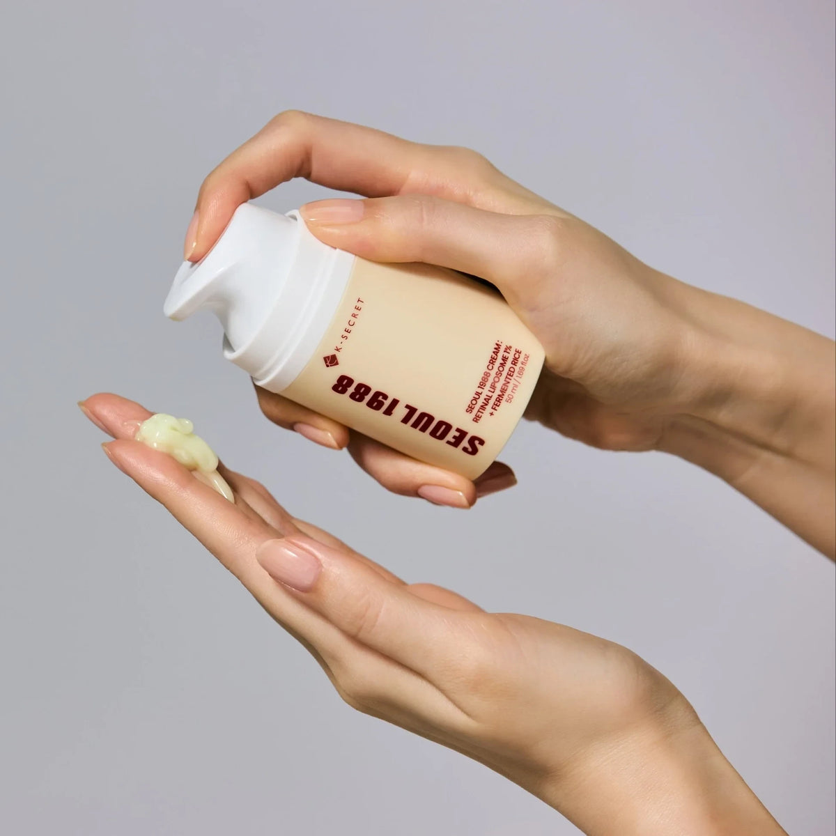 bareskin.lt KSECRET Seoul 1988 retinal face cream being dispensed onto a hand, showing its light yellow texture.