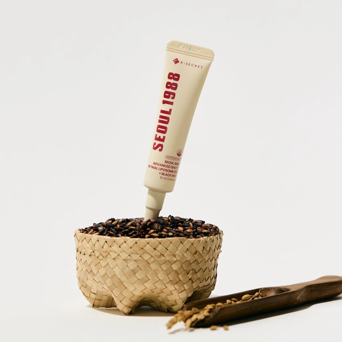 bareskin.lt KSECRET SEOUL 1988 eye cream tube in a small woven basket filled with black rice grains