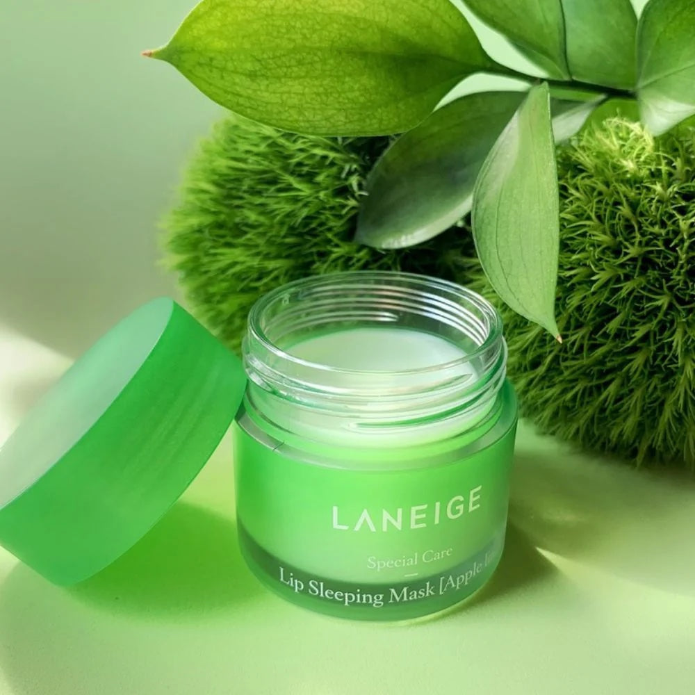 bareskin.lt LANEIGE Lip Sleeping Mask Apple Lime in a green jar with a removed lid, set against lush green foliage.