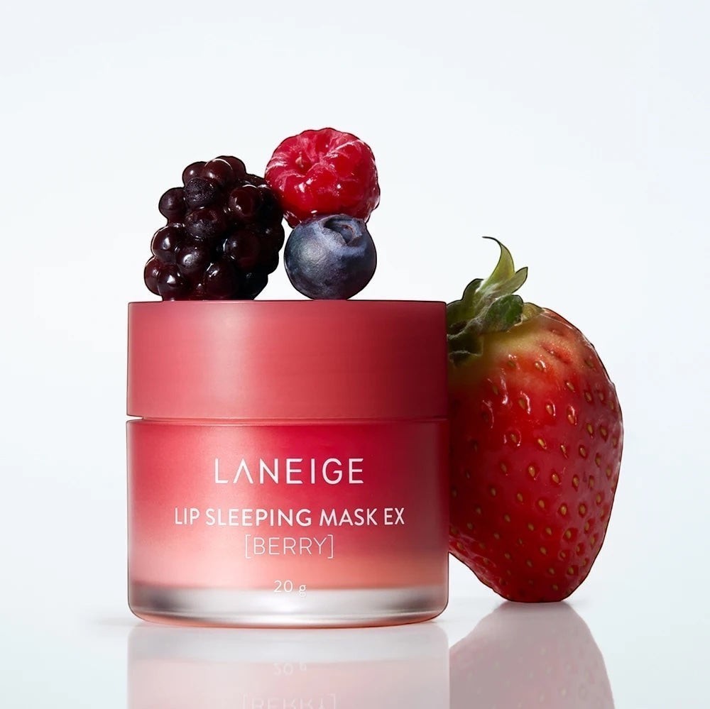 LANEIGE Lip Sleeping Mask Berry by bareskin.lt in a pink jar surrounded by fresh strawberries, blueberries, and blackberries.