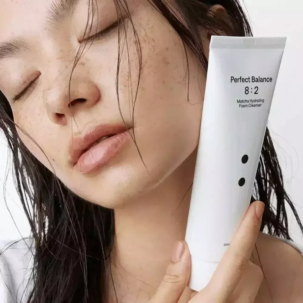bareskin.lt B. Lab Matcha Hydrating Foam Cleanser in a white tube held by a woman with glowing, natural skin