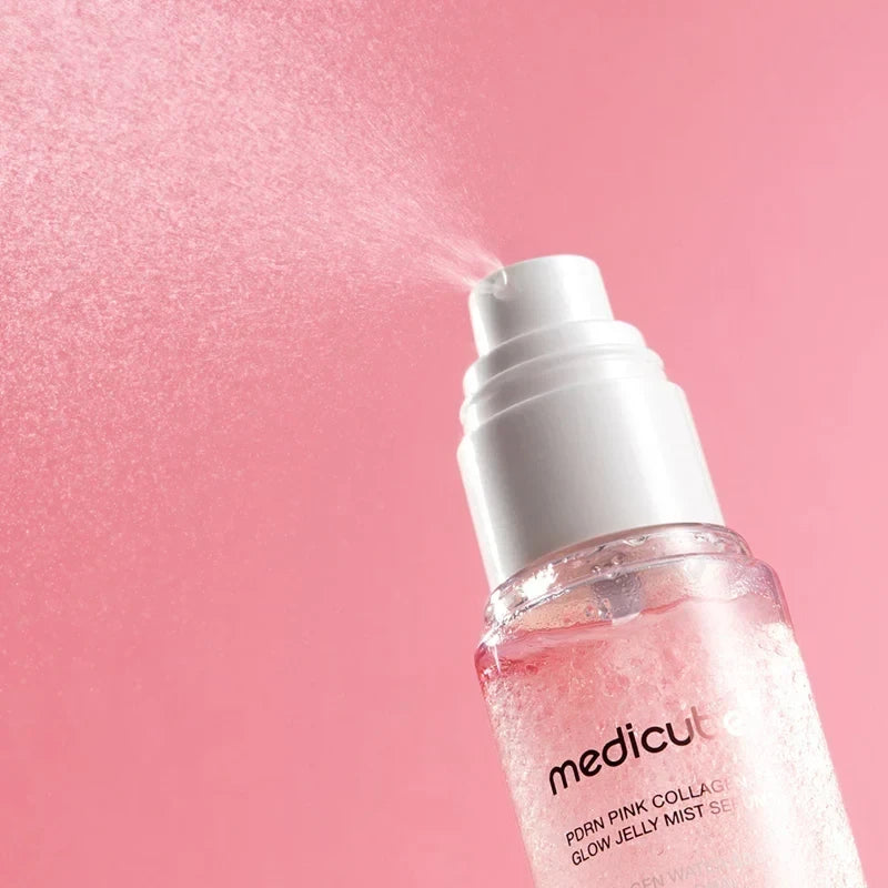 bareskin.lt Medicube PDRN Pink Collagen Glow Jelly Mist Serum spraying a fine hydrating mist against a pink background