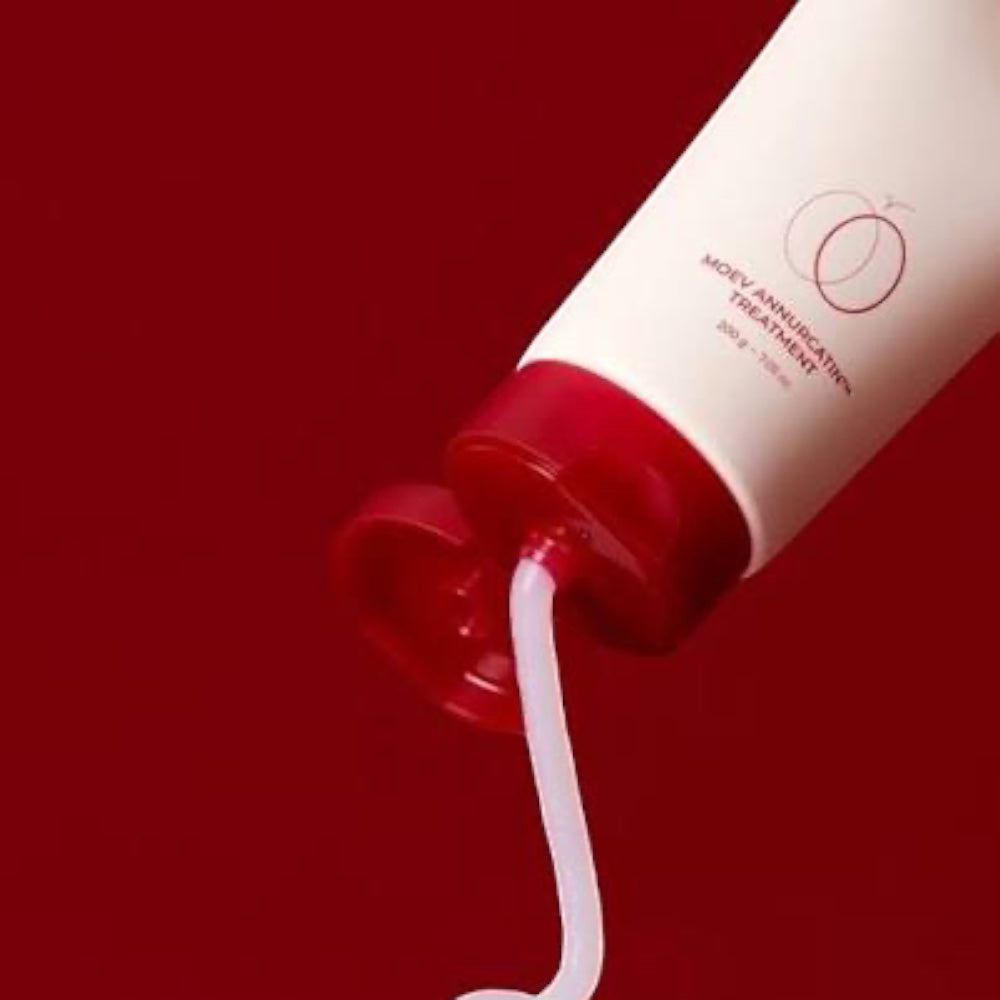 bareskin.lt MOEV Annurcatin hair treatment conditioner being squeezed from a white tube onto a deep red background