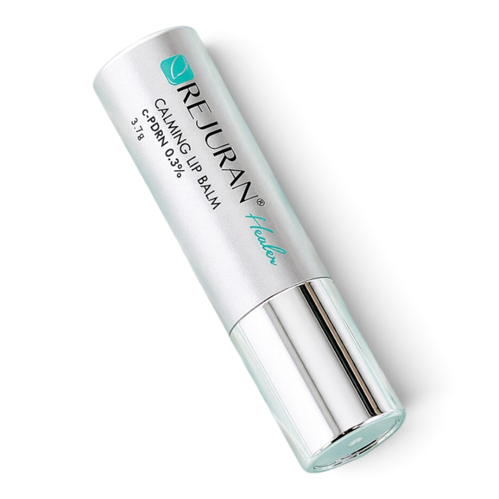bareskin.lt REJURAN Calming Lip Balm in a silver tube, displayed against a background of white cream texture.
