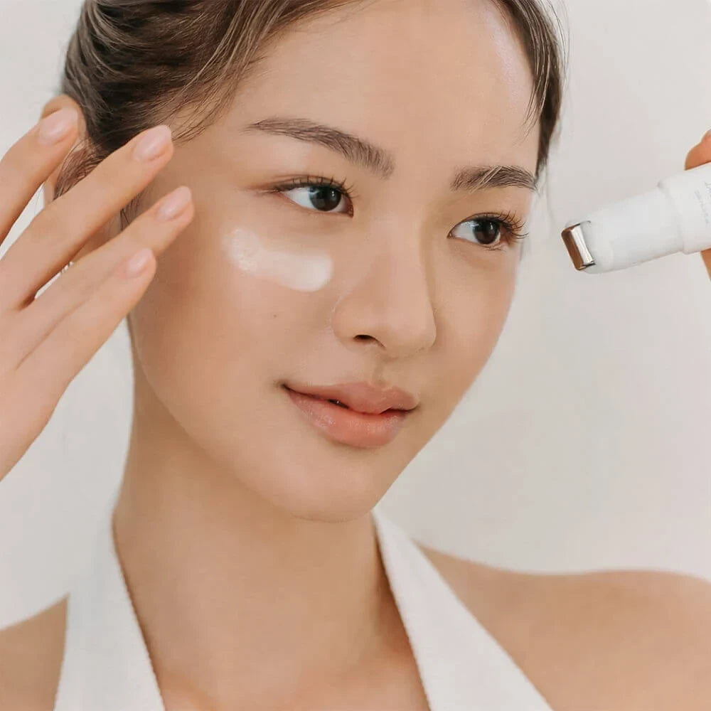 Woman applying Dr. Althea Retinol Flat Iron Eye Roller from bareskin.lt to her under-eye area for skincare.