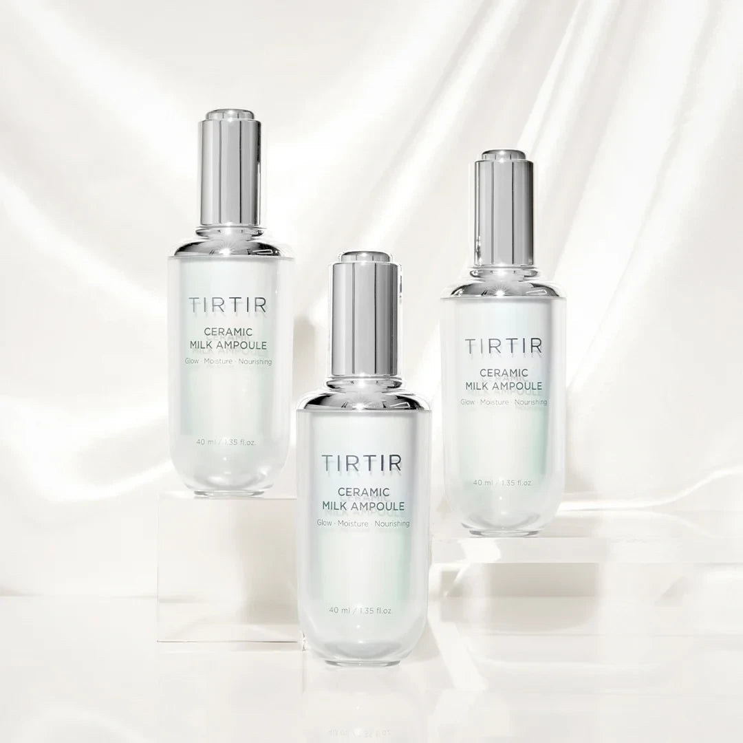Three bottles of bareskin.lt TIRTIR Ceramic Milk Ampoule on white pedestals against a draped silk background.