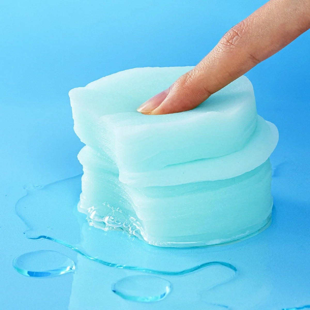 bareskin.lt Torriden DIVE-IN hyaluronic acid essence pads stacked and pressed by a finger on a blue background
