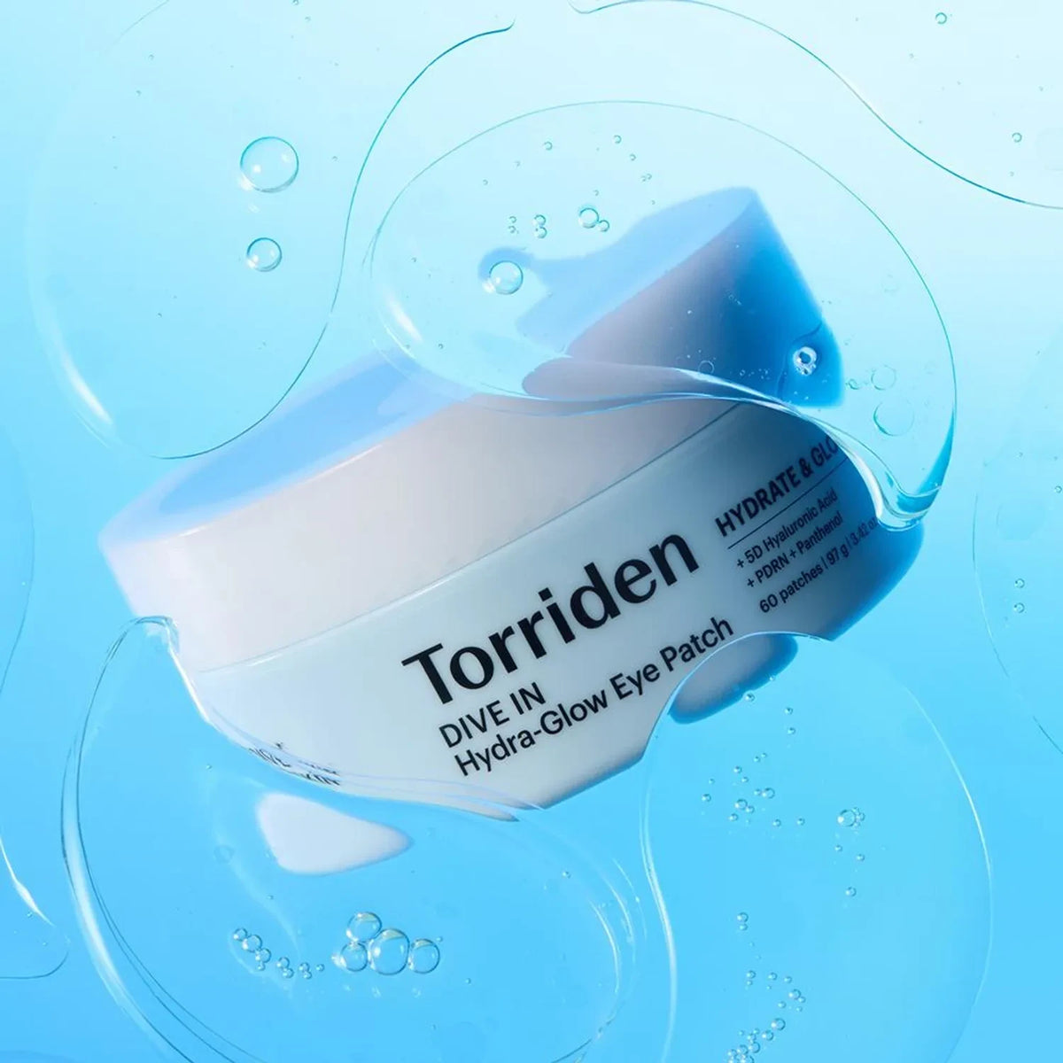 bareskin.lt Torriden Dive In Hydra-Glow Eye Patch jar surrounded by hydrating serum bubbles on a blue background