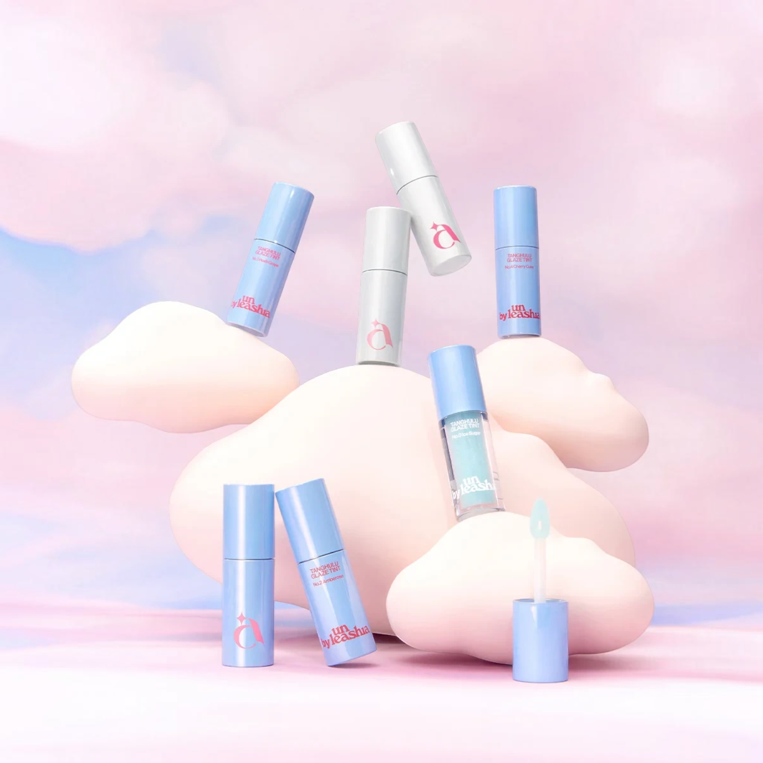 bareskin.lt UNLEASHIA Cloud Kiss Velvet Tint lipsticks in pastel blue and white tubes on soft pink cloud-like props.