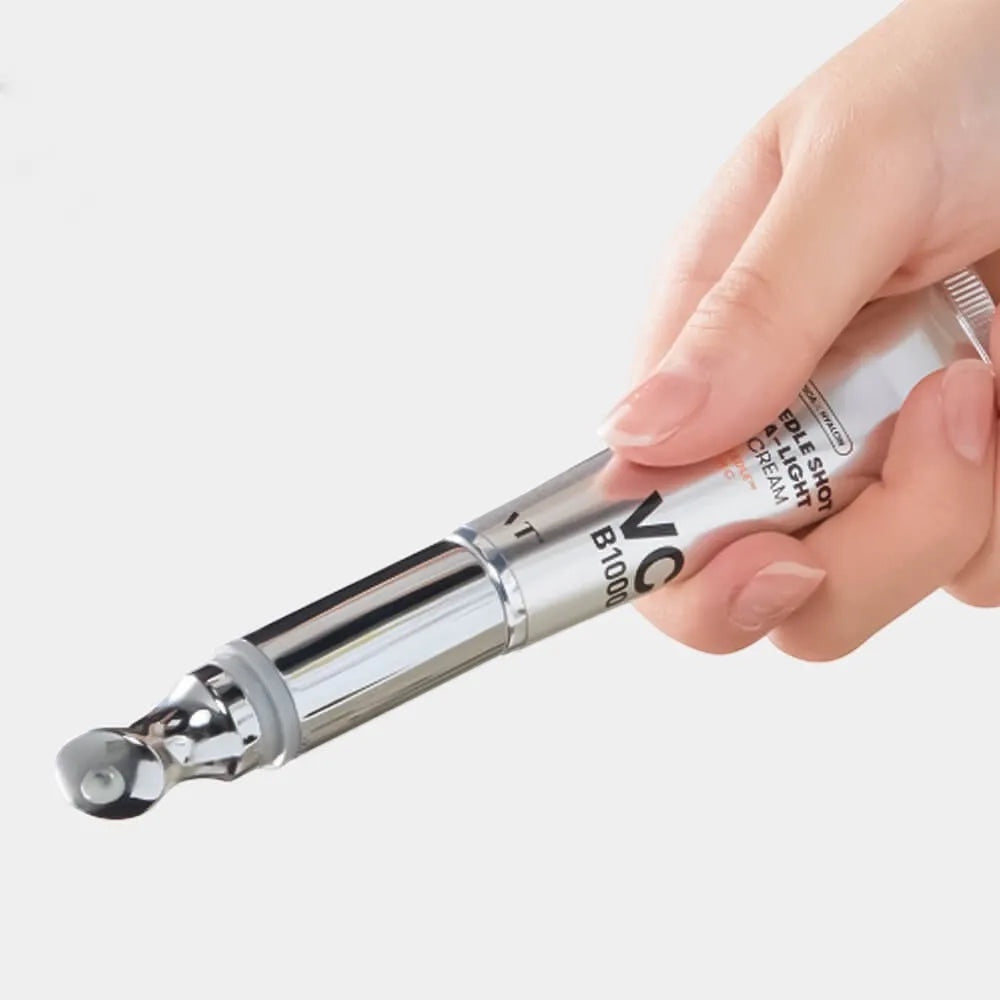 Hand holding silver VT Cosmetics Reedle Shot Vita-Light eye cream tube with a metal applicator tip from bareskin.lt