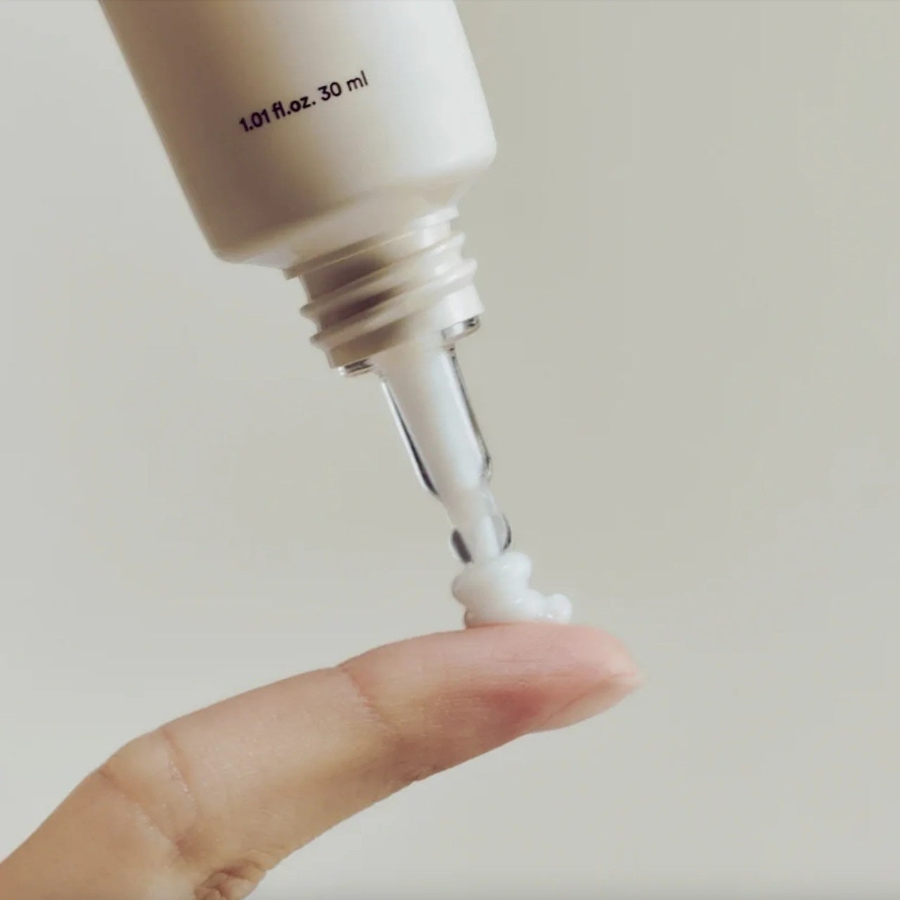 Abib Collagen eye crème from bareskin.lt being dispensed from a 30ml tube onto a finger, showing white cream texture.